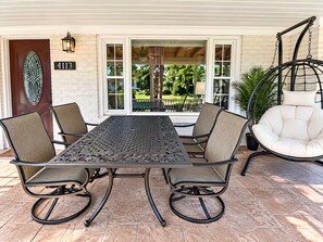 Un patio con una mesa y sillas, una mecedora y una puerta con un número.