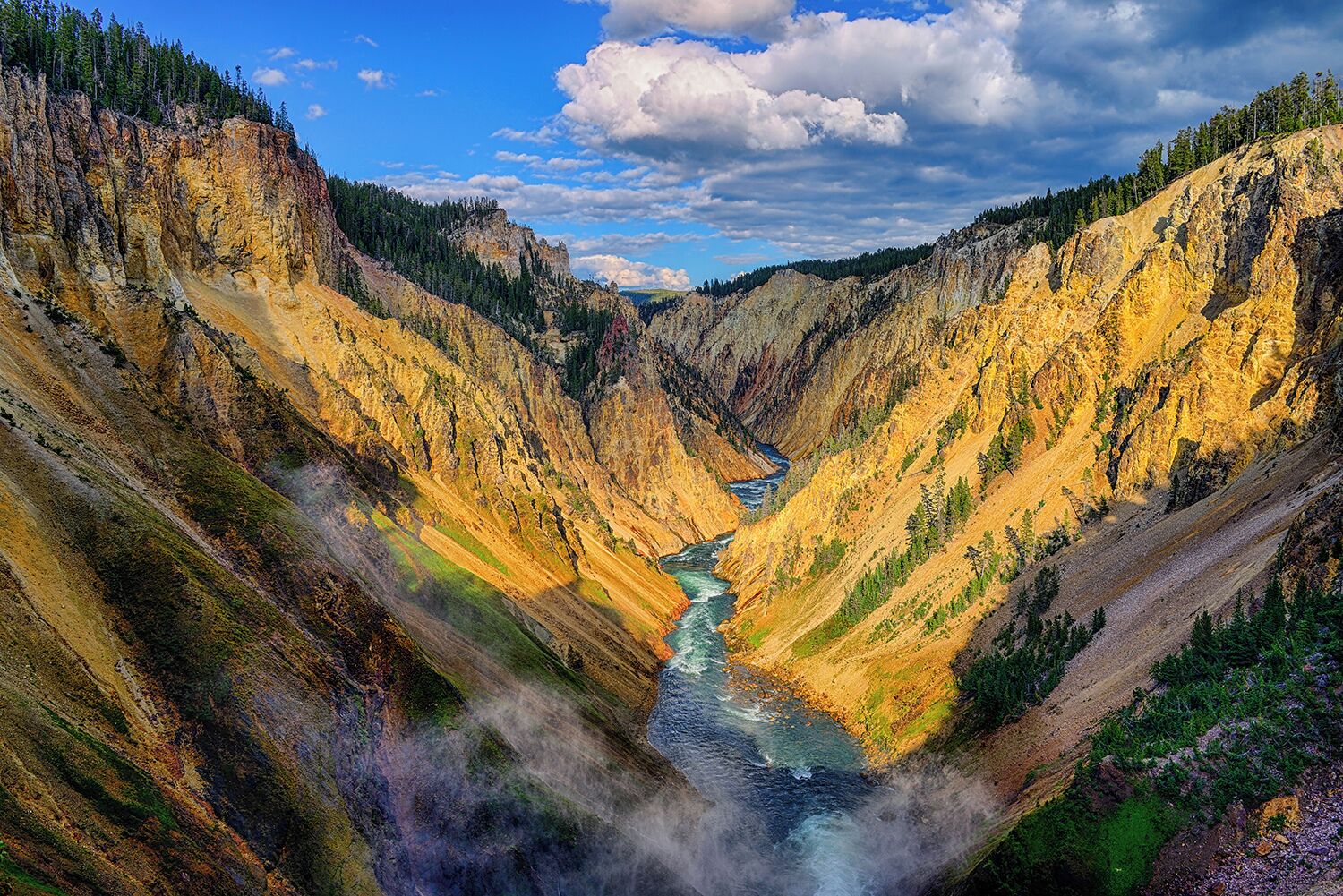 A canyon with a river running through it, surrounded by steep cliffs and dense forests.
