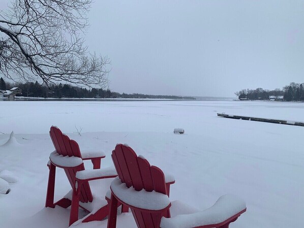 A snow-covered outdoor seating area with red chairs and tables.