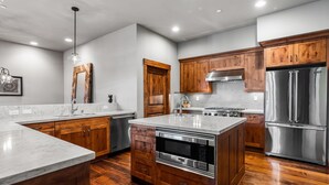 Una cocina moderna con armarios de madera, electrodomésticos de acero inoxidable y encimera de mármol.