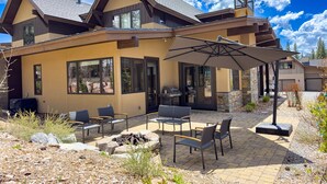 Una casa moderna con un patio amueblado y una parrilla.