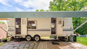 Une maison mobile dotée d’un patio couvert, d’une petite cuisine et d’une porte coulissante.