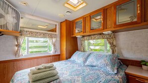 Une chambre à coucher avec un lit, des armoires en bois et une fenêtre avec des rideaux.