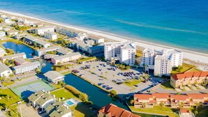 An aerial view of a coastal resort with multiple buildings, a marina, and a beach. - GULF FRONT relaxing condo on GORGEOUS Pensacola Beach. Private pool,low density! (Gulf Breeze)