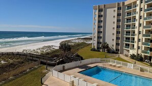 A beachfront hotel with a swimming pool, ocean view, and a well-maintained lawn. - GULF FRONT relaxing condo on GORGEOUS Pensacola Beach. Private pool,low density! (Gulf Breeze)