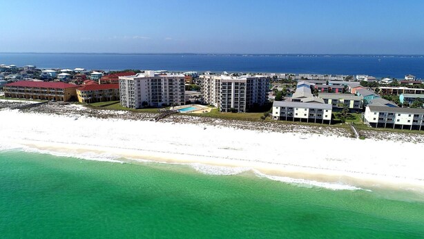 An aerial view of a coastal resort area with beachfront properties, a swimming pool, and a view of the ocean. - GULF FRONT relaxing condo on GORGEOUS Pensacola Beach. Private pool,low density! (Gulf Breeze)
