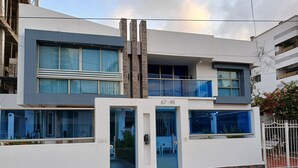 A modern building with a flat facade, large windows, and a balcony.