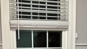 A kitchen with a stainless steel sink, a window with blinds, and a potted plant with red flowers on the windowsill. - North End Retreat (Manchester)