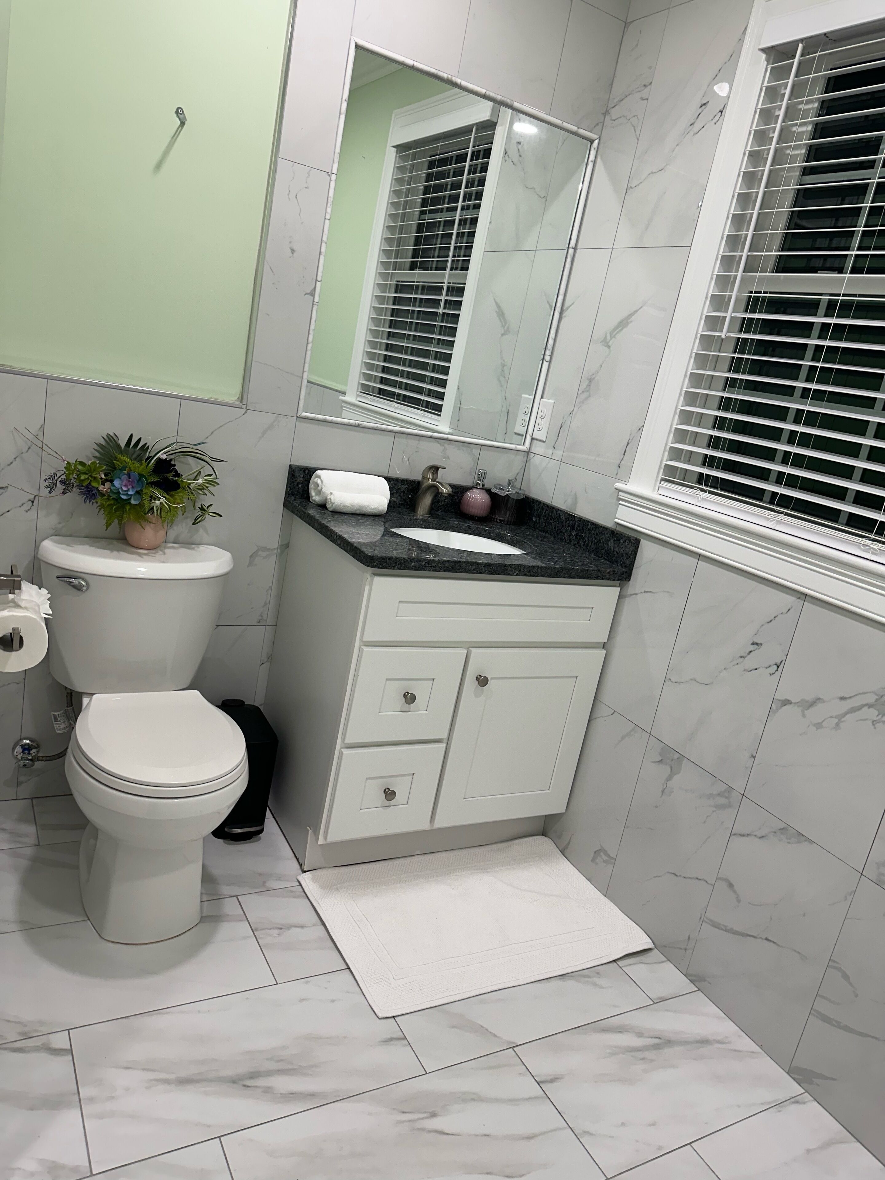 Un baño con inodoro, lavamanos y espejo.