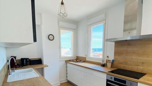 A modern kitchen with a wooden countertop, white cabinetry, a built-in oven, and a window providing a view of the outside. - 🌷 Superb apartment - magnificent view of the Port 🌷 (Saint-Cyprien)