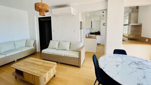 A modern living room with a sofa, a coffee table, and a dining table. - 🌷 Superb apartment - magnificent view of the Port 🌷 (Saint-Cyprien)