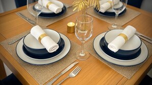 A dining table set with blue and white plates, gold-rimmed napkins, and a clear glass wine glass. - NEW 2 Bed2 Bath Tropical Villa.Ultimate Escape! Private Pool.Covered Patio & BBQ (Savaneta)
