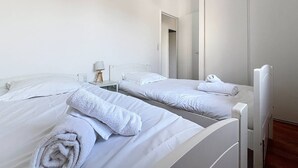 A clean, modern hotel room with two single beds, a bedside table with a lamp, and a large mirror. - Maison 5 Cantons Anglet (ANGLET)