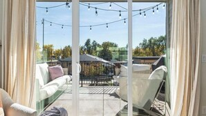 A modern living room with a glass door leading to an outdoor patio area. - Bright/Beautiful new townhome near Old Town Arvada/Quick access to the Mountains (Arvada)