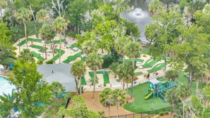 Un campo de golf con búnkeres de arena, un estanque y una zona de juegos.