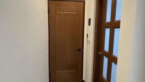 Passadís estret amb una porta de fusta i una porta de vidre.