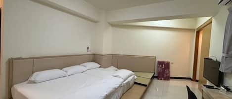 A bedroom with a bed, a desk, and a chair.