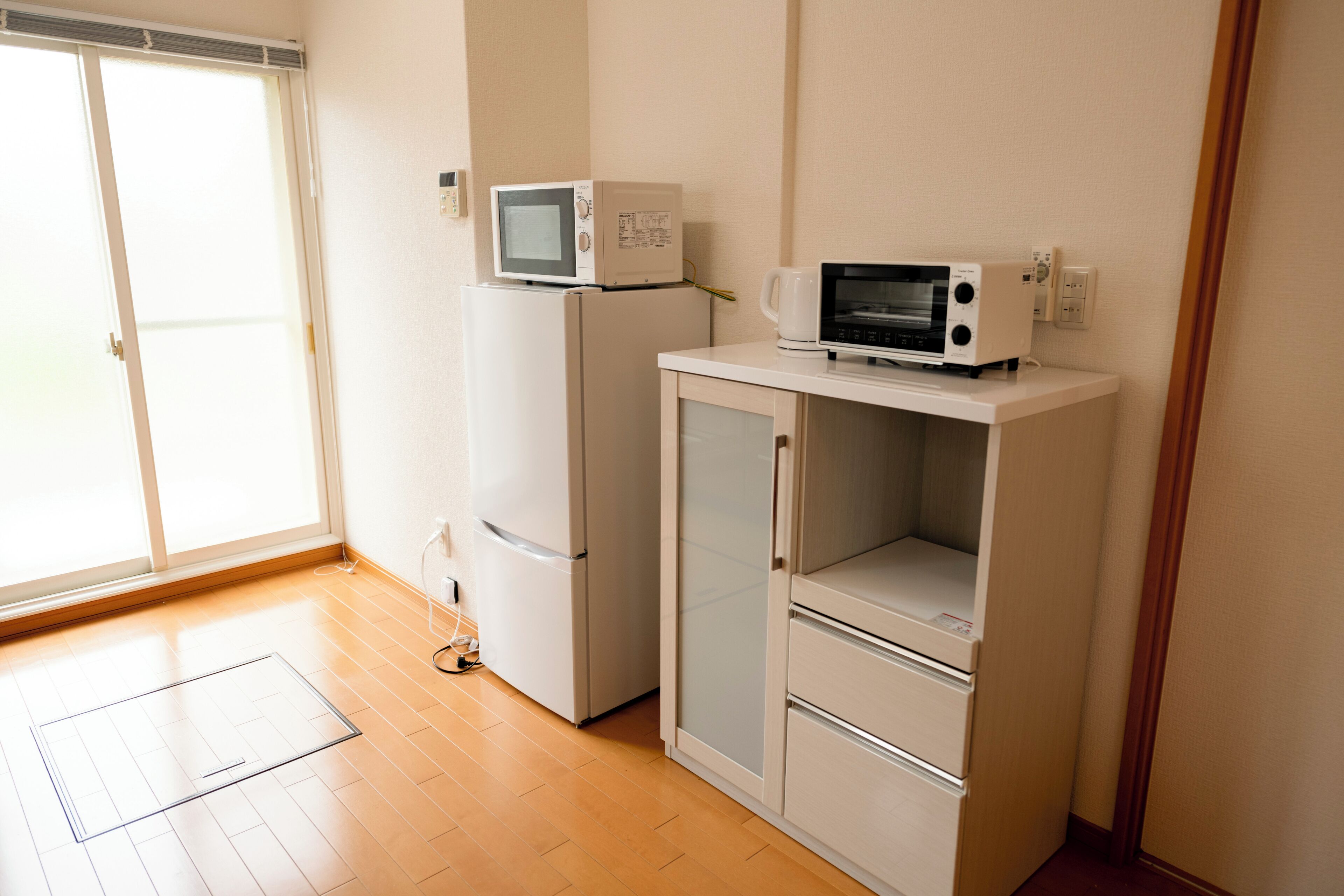 A small kitchenette with a microwave, refrigerator, and a cabinet.