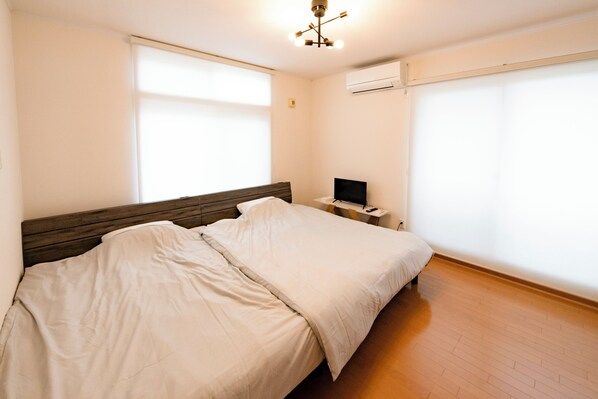 Una camera da letto con un letto grande, un comodino con una lampada e un televisore.