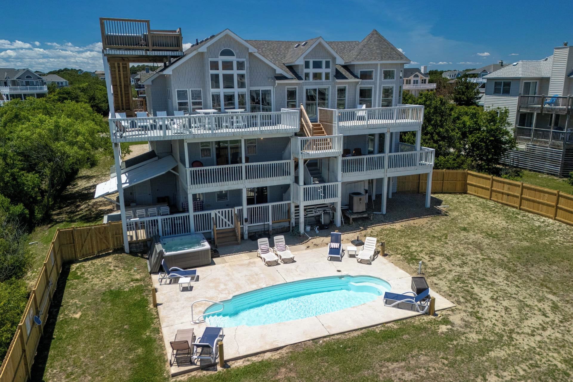 A two-story house with a swimming pool and outdoor furniture.