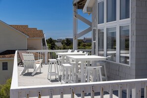 A deck with white furniture and a view of the surrounding neighborhood. - Sea Forevermore: Oceanside, Private Pool, 2 Hot Tubs, Elevator (Corolla)
