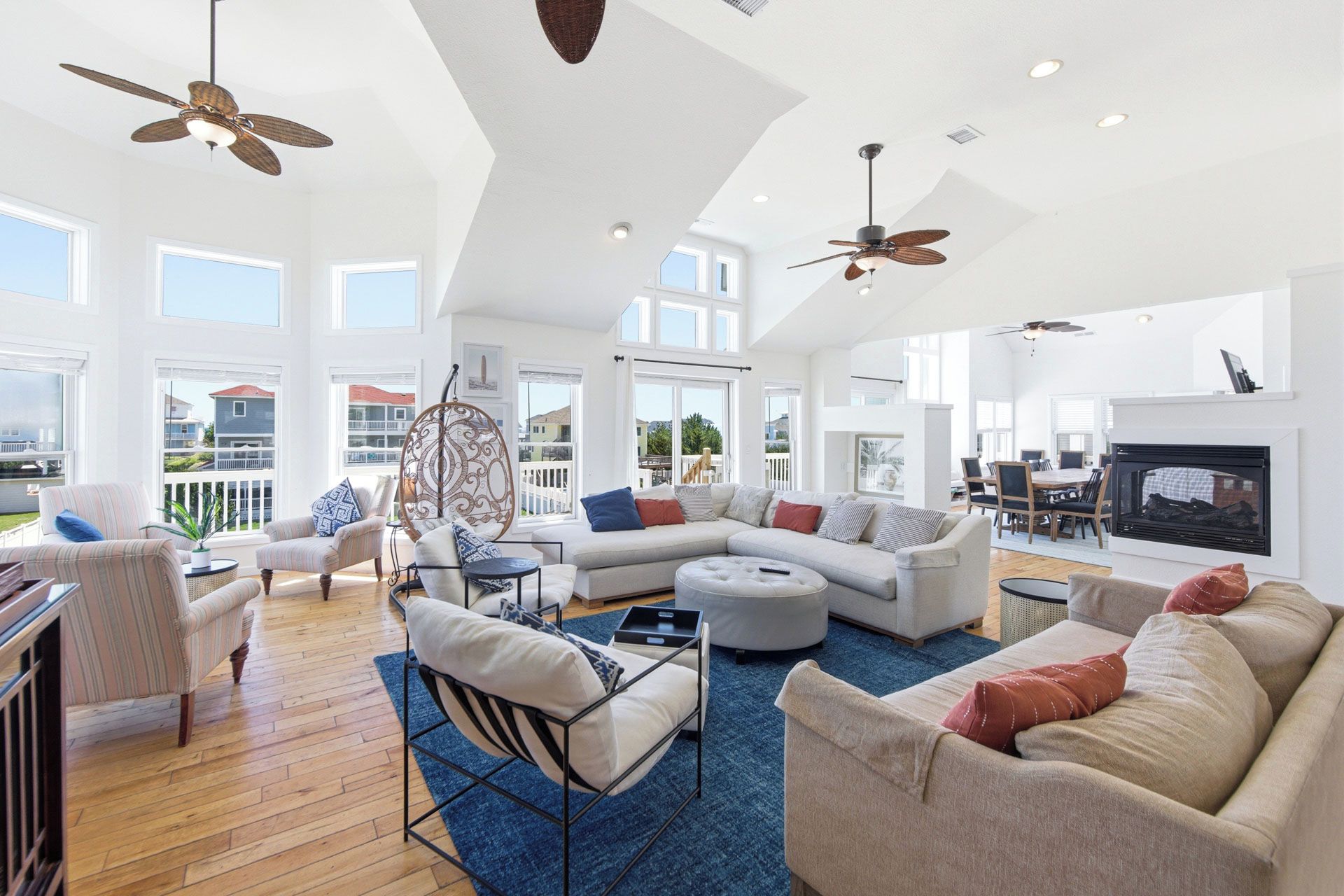 A spacious living room with a sectional sofa, a dining area, and a fireplace.