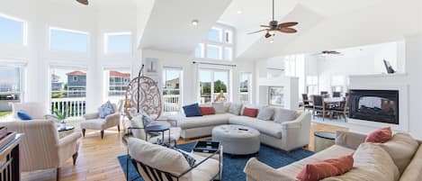 A spacious living room with a sectional sofa, a dining area, and a fireplace.