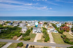 An aerial view of a coastal residential area with houses, a road, and a body of water. - Sea Forevermore: Oceanside, Private Pool, 2 Hot Tubs, Elevator (Corolla)