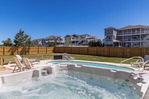 A backyard with a hot tub, lounge chairs, and a wooden fence. - Sea Forevermore: Oceanside, Private Pool, 2 Hot Tubs, Elevator (Corolla)