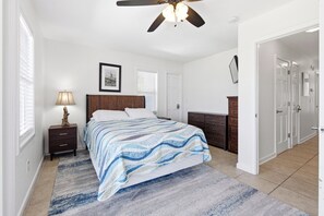 A bedroom with a bed, bedside table, lamp, and a ceiling fan. - Sea Forevermore: Oceanside, Private Pool, 2 Hot Tubs, Elevator (Corolla)
