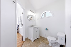 A bathroom with a toilet, sink, and mirror. - Sea Forevermore: Oceanside, Private Pool, 2 Hot Tubs, Elevator (Corolla)