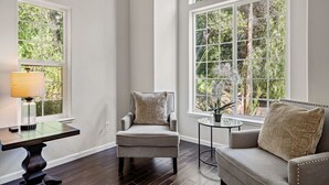 A room with a large arched window, a chair, a small table, and a sofa. - Serene, Stylish, and Spacious 3BD 2BA House Near Wineries (Sonoma)