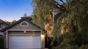 A residential house with a garage, a staircase leading to the entrance, and a well-maintained garden. - Serene, Stylish, and Spacious 3BD 2BA House Near Wineries (Sonoma)