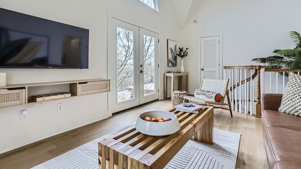 A spacious living room with a large TV, wooden coffee table, and comfortable seating.