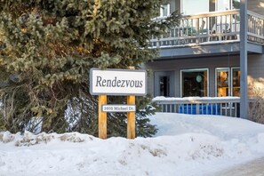 Schild für 'Rendezvous' in der Michael-Dr.-3605 vor einem Gebäude mit einem Balkon.