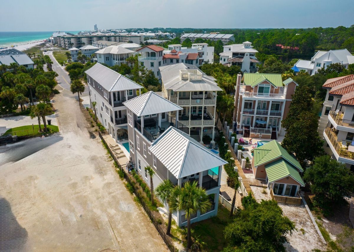 A coastal resort with multiple-story buildings, a beach, and a clear view of the ocean.