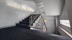Una escalera moderna con barandilla de metal y alfombra estampada.