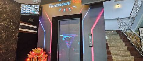 A lobby with a Paramount sign, a staircase, and a traditional Chinese altar.