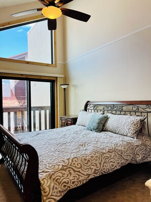 A bedroom with a bed, a ceiling fan, a nightstand, and a view of the outside. - Beautiful 3-bedroom townhome in Avon perfect for your getaway (Avon)