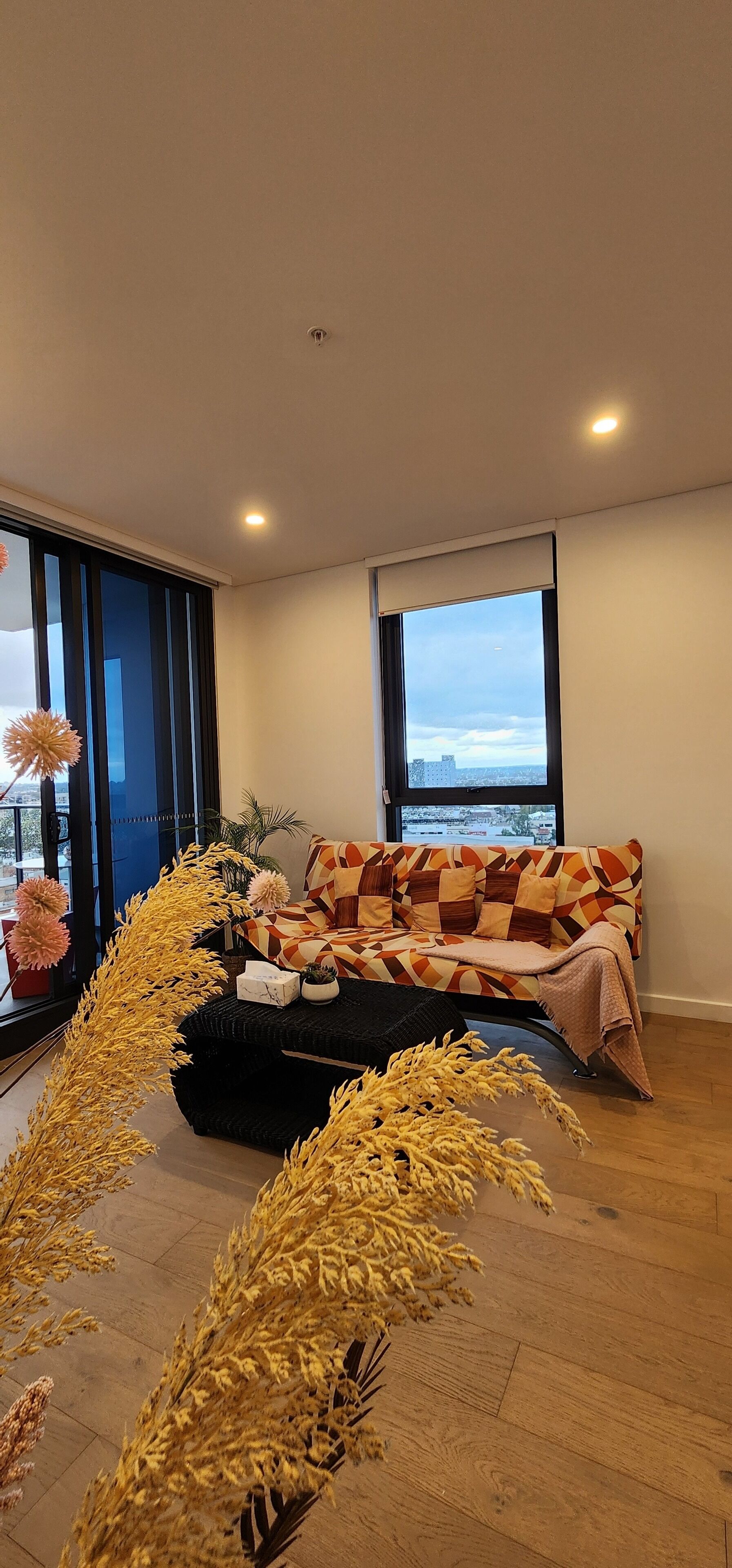 Un salon moderne avec un canapé, une table basse et des plantes décoratives.
