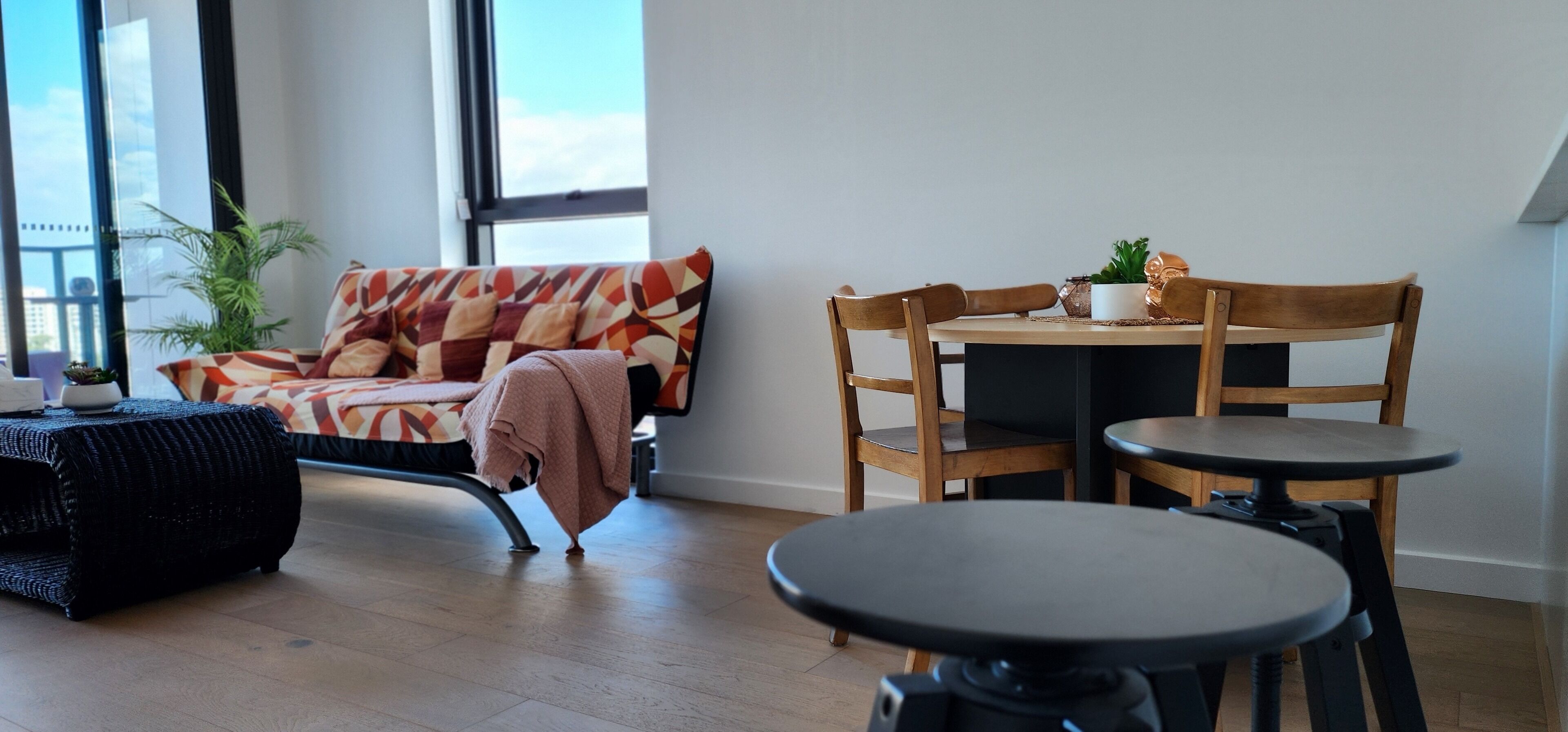 A modern living room with a sofa, a coffee table, and a dining table with chairs.
