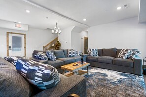 Ein modernes Wohnzimmer mit einer Sofagarnitur, einem Couchtisch und einer Treppe.