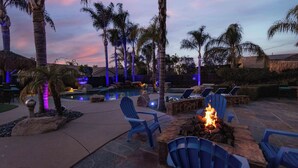 A poolside area with lounge chairs, a fire pit, and palm trees. - Wine Country Resort  -  Close to Wineries (Winchester)