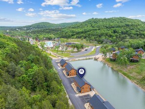 A lakeside resort with multiple cabins, a swimming pool, and a parking area. - Near Thunder Ridge & Table Rock: Private Hot Tub, Community Pool & Free Tickets (Hollister)