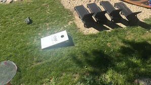 Une terrasse au bord du lac, avec des chaises longues, un kayak jaune et un quai muni d’une échelle.