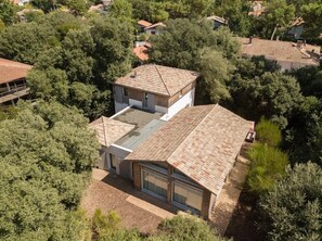 A modern house with a flat roof, surrounded by dense greenery. - Villa Bikiak in the heart of Moulleau near the beach (Arcachon)