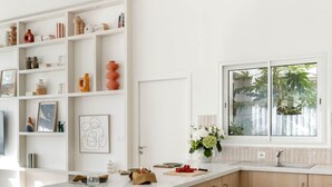 Una cocina moderna con una isla grande, armarios de madera y un salpicadero blanco.