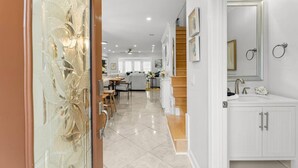 A modern interior with a kitchen, dining area, and a bathroom with a large mirror and sink. - Luxurious Townhome/Beach Access/11 Pools (Panama City)