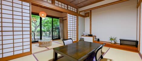 A traditional Japanese room with tatami flooring, a low table, and sliding doors.