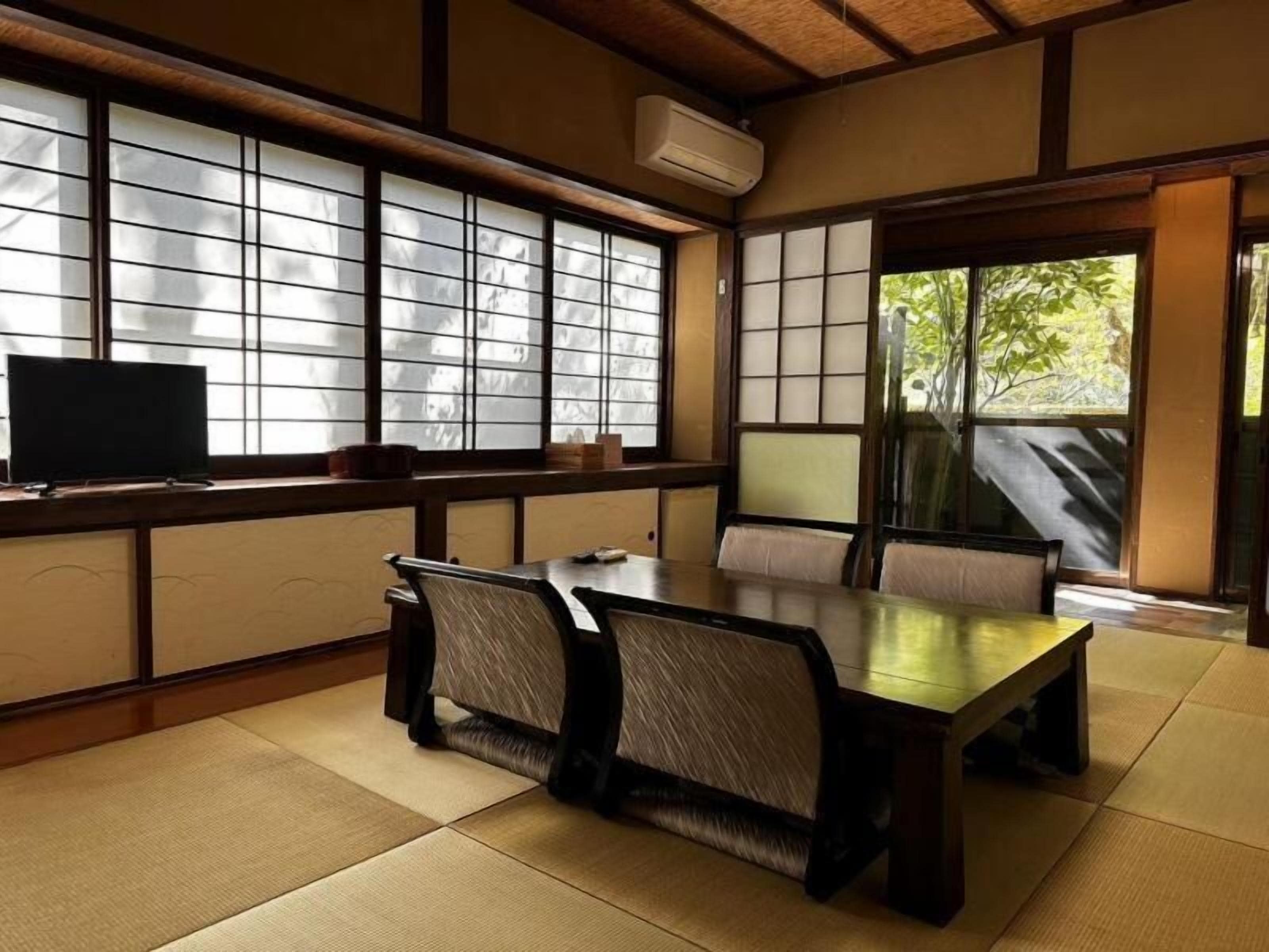 A traditional Japanese-style room with tatami flooring, a low table, and sliding doors.